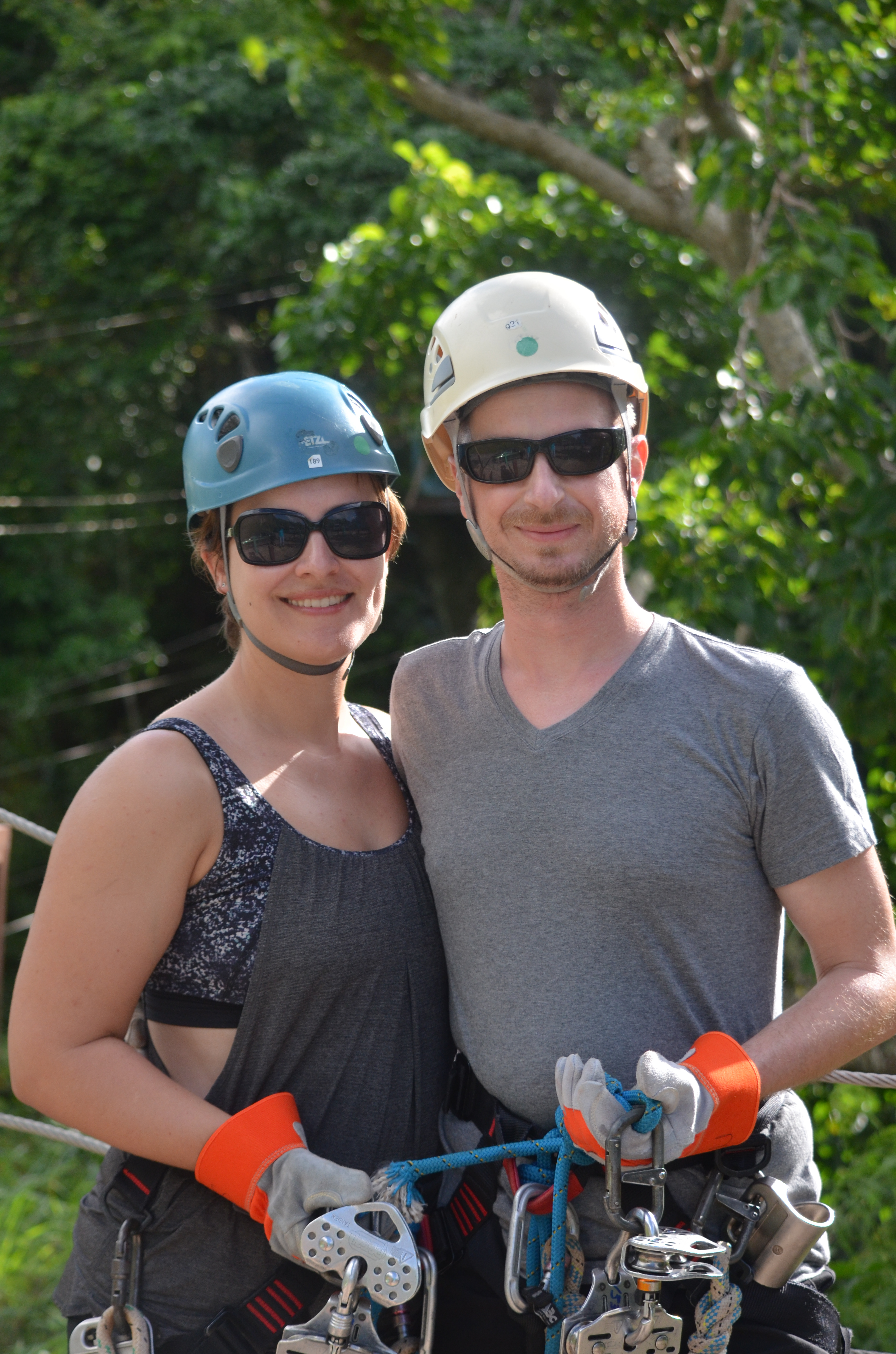 Adam and Shannon holding ziplining equipment.